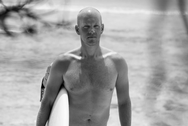 Black&white close up portrait of Scandinavian bald man with surfboard - Fotografie, Obrázek