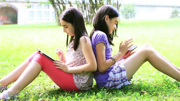 Meninas jogando no tablet digital e smartphone
 - Filmagem, Vídeo
