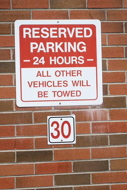 Señal de estacionamiento reservada para los visitantes en el bloque de oficinas
 - Foto, imagen