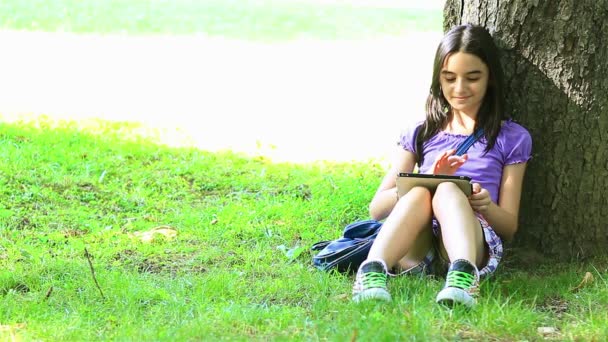 dospívající dívka pomocí digitálních tabletu v parku - Záběry, video