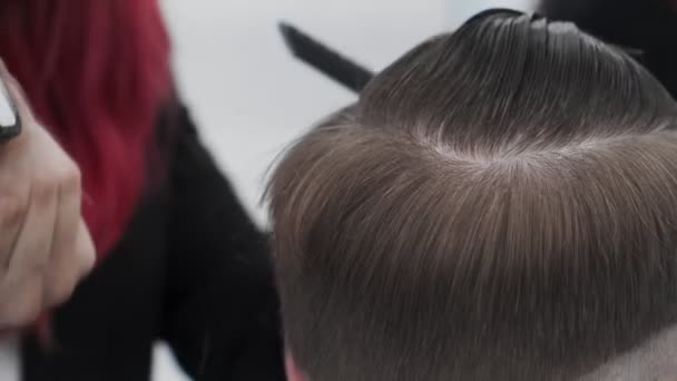 サロンでトリマーで男の髪を切断します。閉じる頭を上の男とともにトレンディなヘアカット - 映像、動画