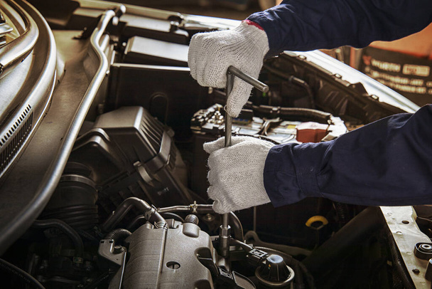 Hands of car mechanic with wrench in garage.Auto mechanic working in auto repair service.Repair service.Car repair and maintenance.  - Foto, imagen