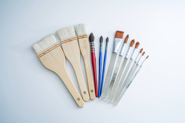 A row of all kinds of watercolor brushes on the white desk. Painter artist brush tool - Photo, Image