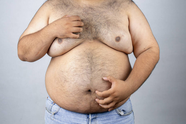 Hombres gordos sobre fondo blanco. Gordo con barriga grande. El hombre gordo come mucha comida, peso extra, dieta
. - Foto, imagen