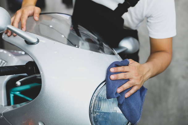 Working man cleaning headlight motorcycle - motorcycle detailing  concept. Selective focus. - 写真・画像