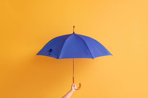 Hand with stylish umbrella on color background - Фото, изображение