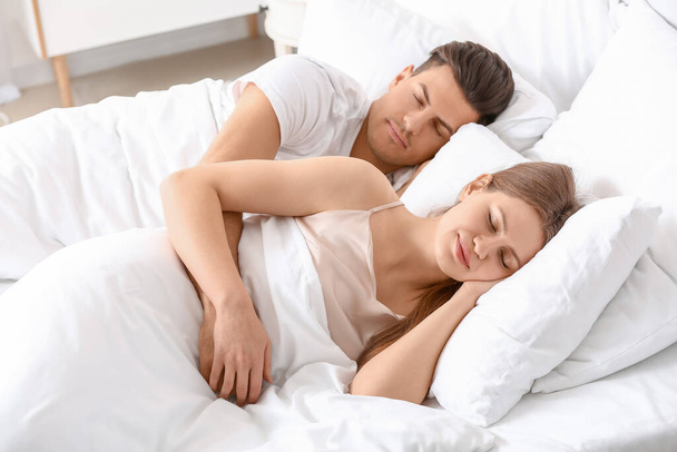 幸せな若いカップルの朝のベッドで寝て - 写真・画像