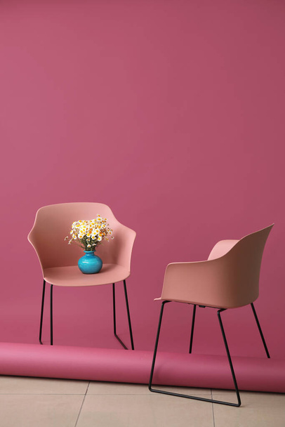 Vase mit schönen Kamillen und Stühlen drinnen - Foto, Bild