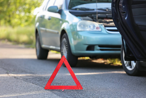 Yolda kaza yaptıktan sonra kırık arabaların yanında dur işareti var. - Fotoğraf, Görsel