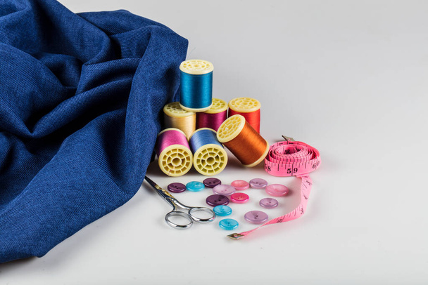 Kit de costura: tesoura, fita métrica, dedais, fios e botões. Tesoura, bobinas com fio e agulhas, tecido
. - Foto, Imagem