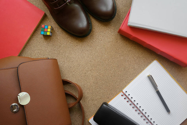 Flat lay books, backpack, notebook, boots, rubik's cube, pen on the background of cork board. - Valokuva, kuva