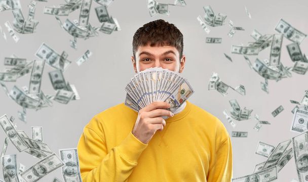 happy young man in yellow sweatshirt with money - Fotografie, Obrázek