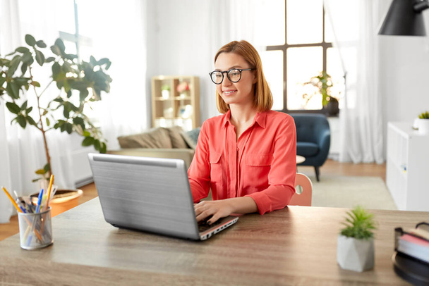 happy woman with laptop working at home office - Foto, imagen