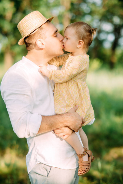 Giovane padre bacia sua figlia mentre cammina nel parco
. - Foto, immagini