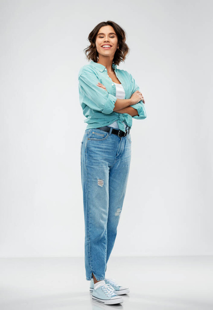 smiling young woman in turquoise shirt and jeans - Фото, зображення