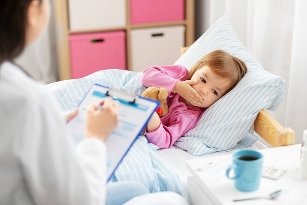 doctor and ill coughing little girl in bed at home - Foto, Imagem