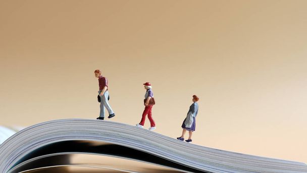 Miniature people walking on open pages. - Photo, Image