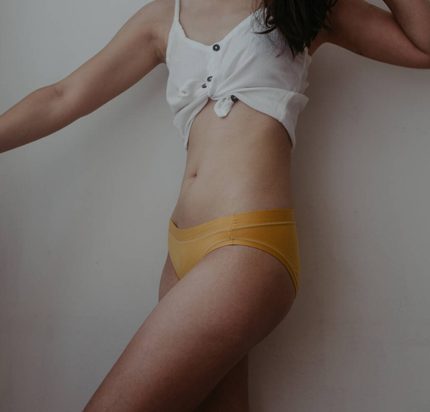 woman hips in yellow lingerie - Foto, afbeelding