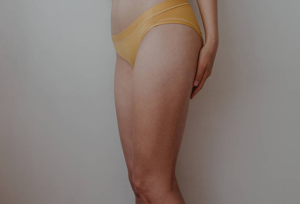 woman hips in yellow lingerie - 写真・画像