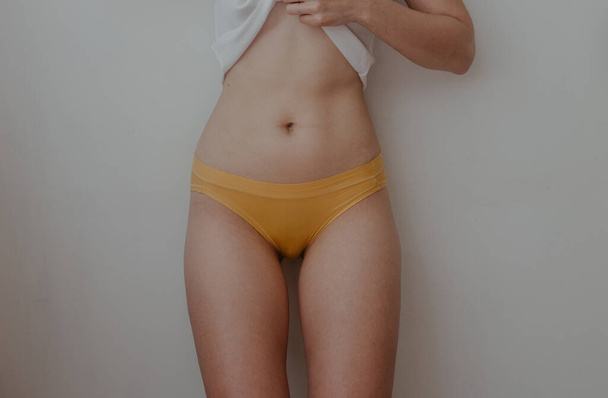 vrouw heupen in geel lingerie - Foto, afbeelding