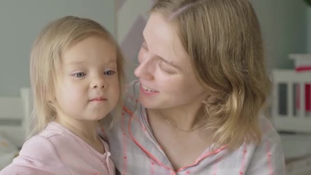 Slow motion. Close-up. Portrait. A pregnant woman hugs and kisses her little daughter. - Materiał filmowy, wideo