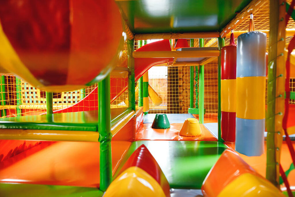 Cerca de parque infantil inflable moderno para niños en interiores. Zona infantil colorida con red de seguridad para jugar
 - Foto, imagen
