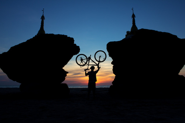 silueta de un ciclista entre dos estupas en el fondo de
 - Foto, imagen
