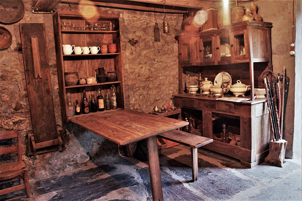 benches and folding tables of old wood in rural house of Galicia, old country kitchen with hanging pans, kitchen of a rural house in Galicia, old wooden furniture,  typical rural cuisine of Galicia, - Photo, Image
