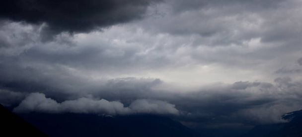 Nuvole temporalesche scure e nuvole di pioggia pendono sulla valle - minaccioso spettacolo naturale in Alto Adige Italia - Foto, immagini