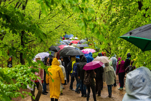 Plitvice, Kroatië - 01 mei 2016: Toeristische wandelingen in de regen in Nationaal Park Plitvice meren, Kroatië - Foto, afbeelding