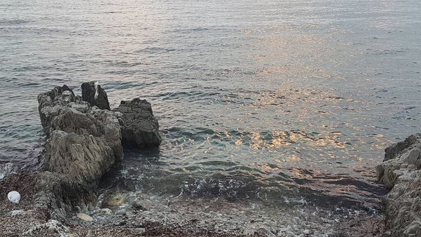 Пляж Кальча в Италии на закате в пасмурный день с камнями. Высокое качество фото - Фото, изображение