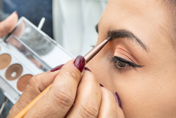 beautiful woman applying makeup on her face  - 写真・画像