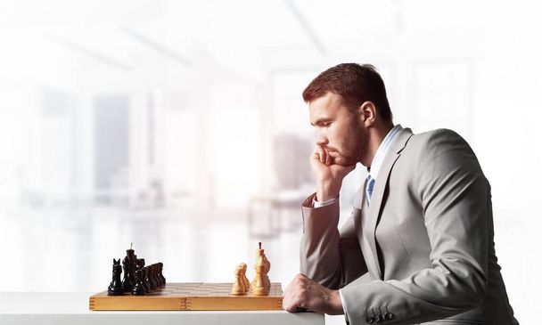 Businessman moving chess figure in chessboard - 写真・画像