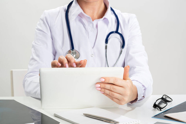 Close up female doctor hands using tablet computer - Foto, Imagen