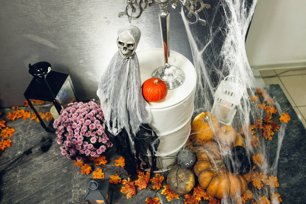 Fénykép tökökkel, ijesztő szellem koponyával és pókhálóval Halloween partira. Háttér a halloween ünnepléshez. Kreatív dekorációk Halloween party fekete fallal - Fotó, kép