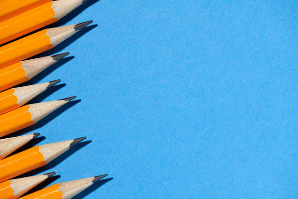 grafitowe ołówki na niebieskim tle makro zdjęcia, materiały szkolne i biurowe - Zdjęcie, obraz