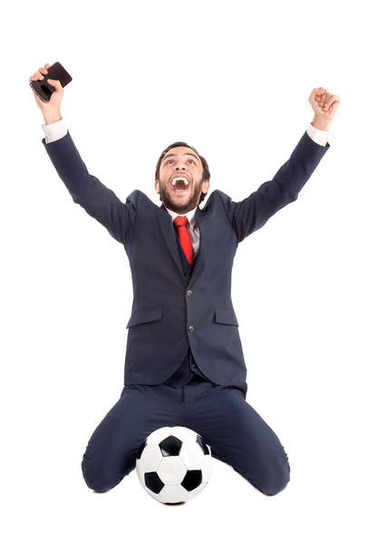 Futbol topu sahibi iş adamı beyazlar içinde yalnız kutluyor. - Fotoğraf, Görsel
