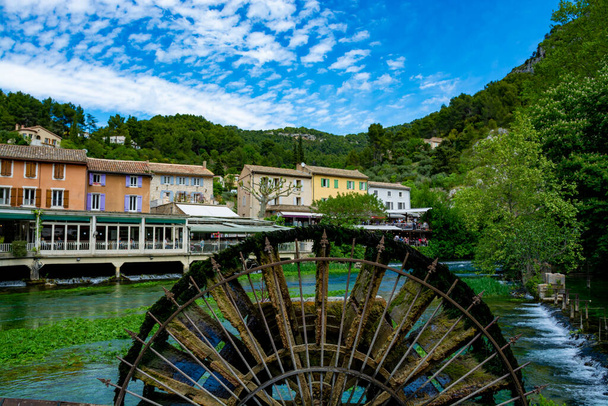 Dél-Franciaország, kilátás a kis turisztikai Provencal város költő Petrarch Fontaine-de-vaucluse smaragd zöld vizek Sorgue folyó - Fotó, kép