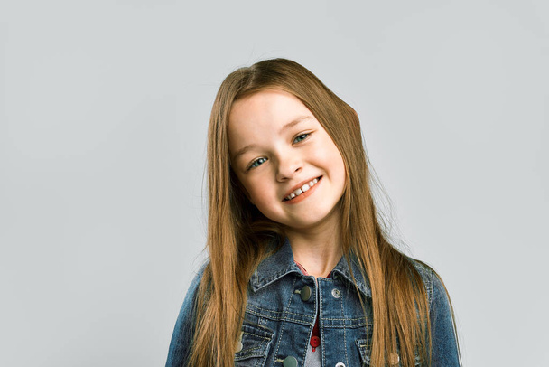 portrait of a cute little girl. gray studio background - Фото, изображение