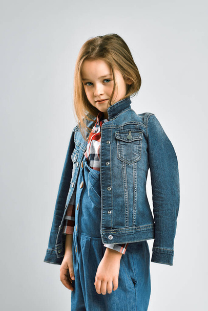 studio portrait of a little girl in a jeans suit - Zdjęcie, obraz