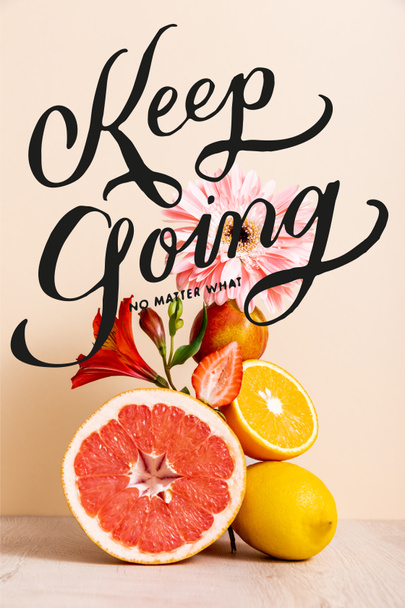 floral and fruit composition with citrus fruits, strawberry and peach near keep going no matter what lettering on beige  - Foto, immagini