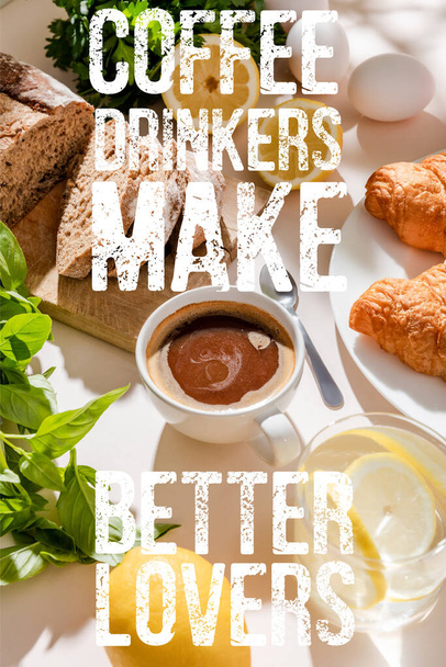 fresh croissants, bread, greenery, eggs, lemon water and cup of coffee for breakfast on grey table with coffee drinkers make better lovers lettering - Photo, Image