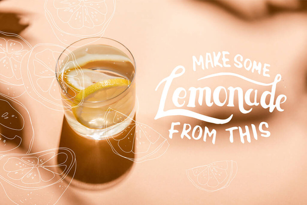 egy pohár friss víz citromszeletekkel bézsen némi limonádéval ebből a betűből.  - Fotó, kép