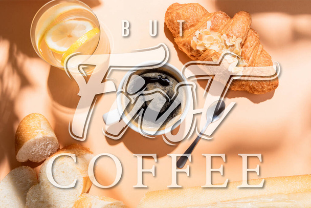 top view of coffee, water, baguette and croissant for breakfast on beige table with but first coffee lettering - Foto, Bild