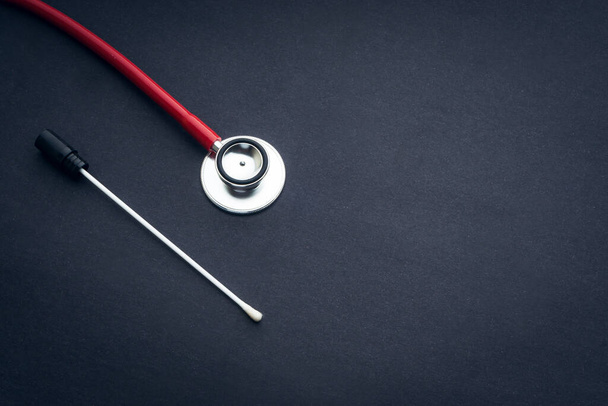 Medical swab and stethoscope closeup on black background. Health care and copy space concept - Photo, Image