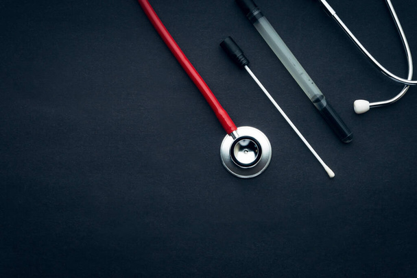 Medical swab and stethoscope closeup on black background. Health care and copy space concept - Foto, Imagem