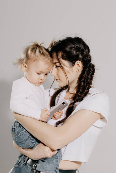 happy mother and daughter on shooting in the studio on a white background - Zdjęcie, obraz