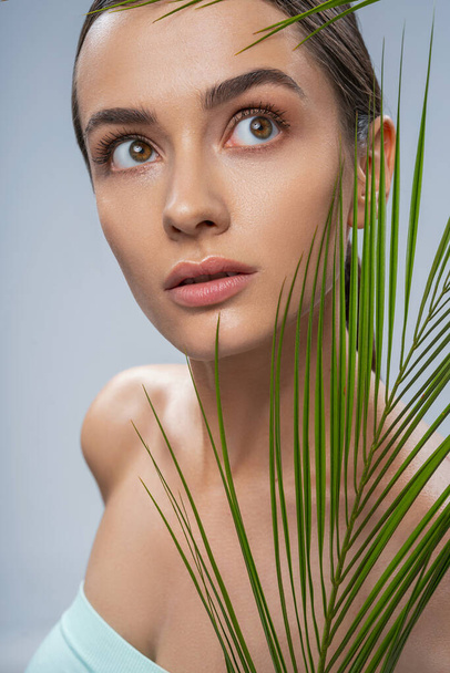 Relaxed beautiful woman with green palm leaf - Foto, Bild