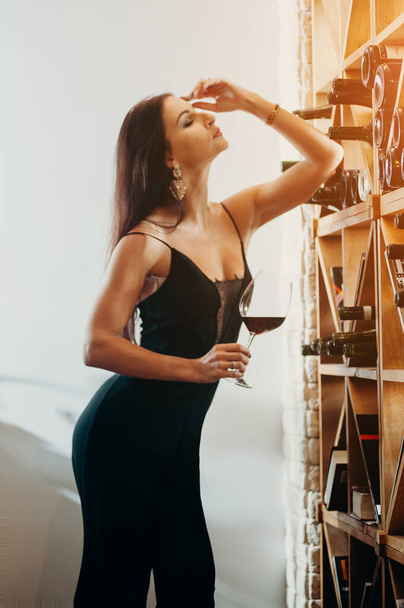 Relax time and alcohol theme. Beautiful happy lady drinking glass of red wine. - Foto, afbeelding