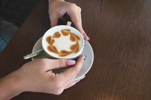 Nainen pitelee kahvikuppia kahvilassa. Lähikuva, kopioi tilaa, ylhäältä - Valokuva, kuva